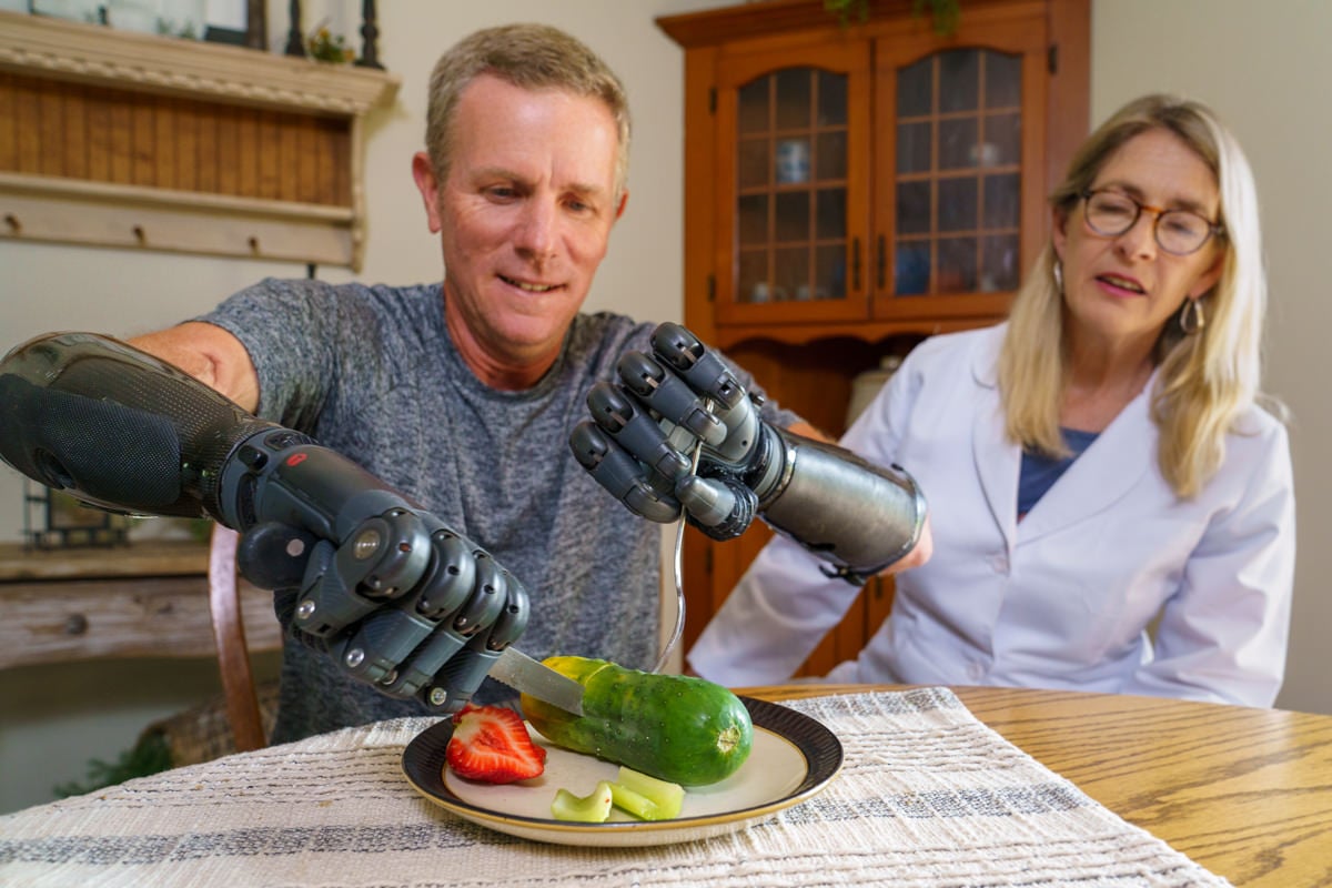 Arm Dynamics Clinical Therapy Specialist working with Gerry Kinney, a bilateral amputee on using his myoelectric TASKA hand to perform Activities of Daily Living