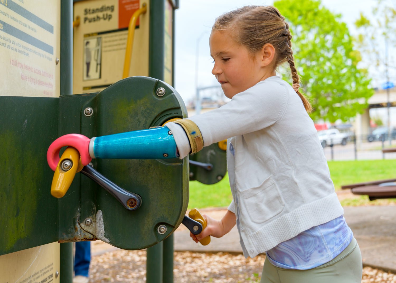 Autumn using her Activity-Specific Swinger device on the playground