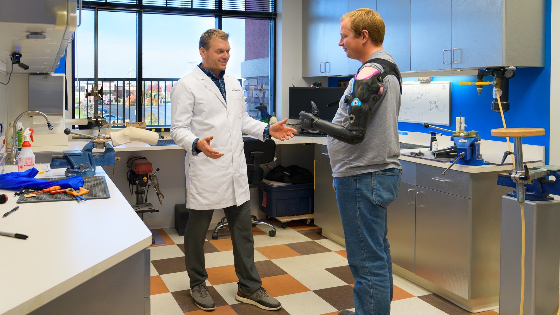 Andy Sabean, CP/LP, talks with a patient about the suspension system for his high-level prothesis.